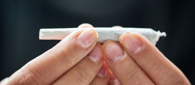 two hands are shown holding a joint